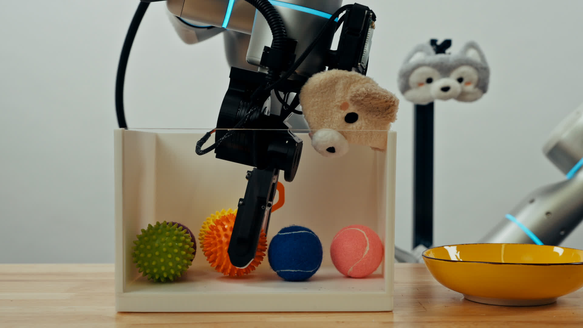 Robot gripper using tactile sensors to grasp a textured orange ball from a box.